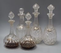 A pair of Victorian cut glass decanters, with silver labels and three other decanters with labels,