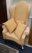 A Carolean style carved oak wing armchair