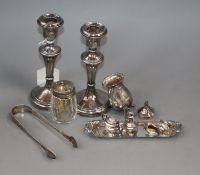 A pair of silver mounted candlesticks, two silver mounted condiments, a pair of sugar tongs and