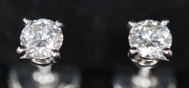 A pair of Cartier platinum set solitaire diamond ear studs, each stone weighing approximately 0.