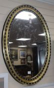 A pair of Irish style oval mirrors with glass-mounted gilt and ebonised frames H.105cm