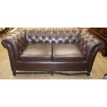 A buttoned brown leather buttonback two seater chesterfield settee W.approx. 175cm