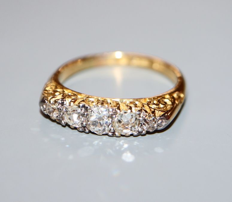 An 18ct and graduated five stone diamond ring, size L.