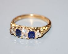 An early 20th century 18ct, two stone sapphire and four stone diamond ring, size L.