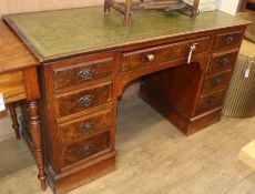 An early 20th century figured walnut kneehole desk W.135cm