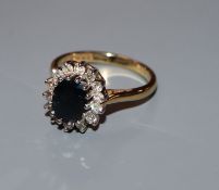 A modern 18ct gold, sapphire and diamond oval cluster ring, size P/Q.