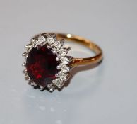 A modern 18ct gold, red garnet and diamond oval cluster ring, size S.