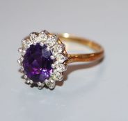 A modern 18ct gold, amethyst and diamond oval cluster ring, size S/T.