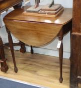 A Regency mahogany Pembroke table, with oval flap top and fluted slender baluster legs W.74cm