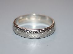 An engraved platinum wedding band, 5 grams, size O.