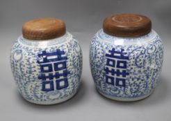 A pair of 19th century Chinese blue and white 'shuangxi' jars, wood covers height 20.5cm