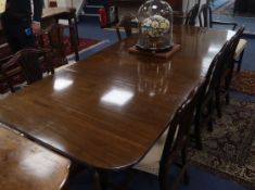 A Regency design mahogany two pillar dining table, the top with reeded edge, with two spare
