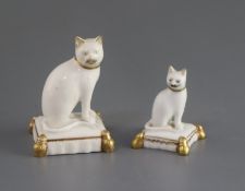 Two Rockingham porcelain figures of cats, c.1830, each seated on a tasselled cushion, the largest