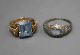 A 14k white metal and aquamarine ring and a 750 yellow metal and synthetic spinel? ring.