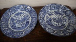 A pair of early 18th century Arita blue and white chargers, painted with peonies and grasses