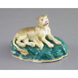 A Staffordshire porcelain group of a lioness and cub, c.1830-45, on a green rockwork base, L.