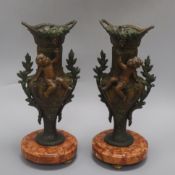 A pair of French bronzed spelter vases, mounted with cherubs, on marble bases height 33cm