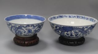 Two 19th century Chinese blue and white 'dragon' bowls, Kangxi mark, on wooden stands diameter 25.