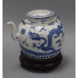 A Chinese blue and white 'dragon' teapot, Daoguang, on carved wooden stand overall height 21cm