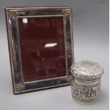 An Indian repousse white metal jar and cover and a silver plated photograph frame.