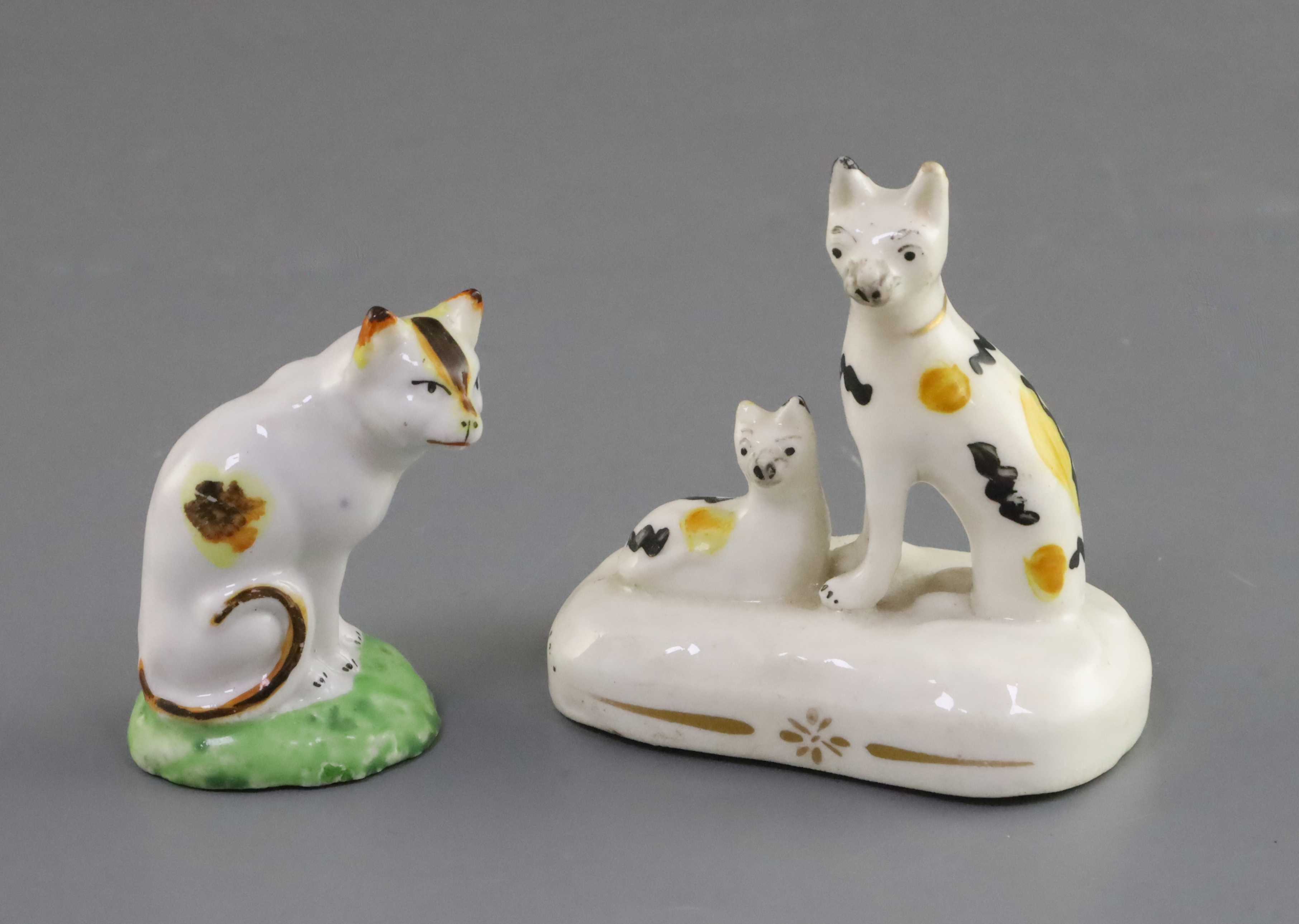 A Staffordshire porcelain seated cat and kitten group and a similar figure of a cat, c.1835-50, each