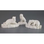 A pair of Staffordshire biscuit porcelain figures of leopards and a similar figure of a lion, c.