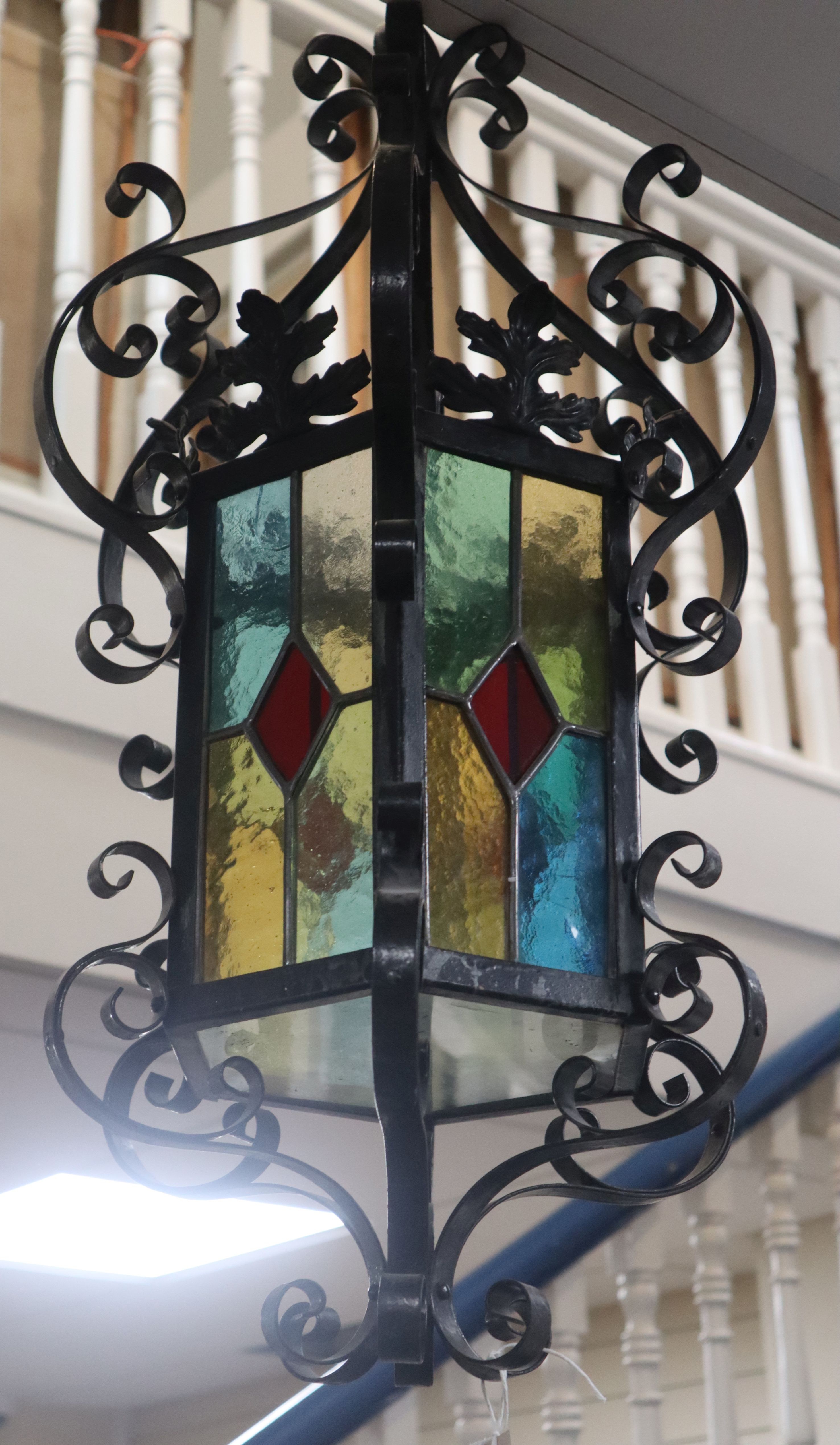 A wrought iron stained glass hexagonal hall lantern