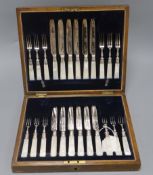 A cased set of twelve pairs of fruit eaters with mother of pearl handles and silver collars