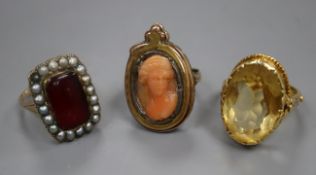 Three assorted yellow metal gem set rings including a carved coral cameo.