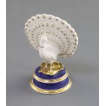 A Chamberlain Worcester porcelain figure of a peacock, c.1820-40, on a circular dry blue and gilt