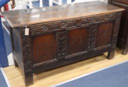 A large 18th century oak coffer, the panelled front carved with the initials M H and dated 1714 W.