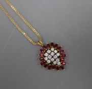 A modern ruby and diamond set cluster pendant, on a yellow metal chain, pendant overall 30mm.