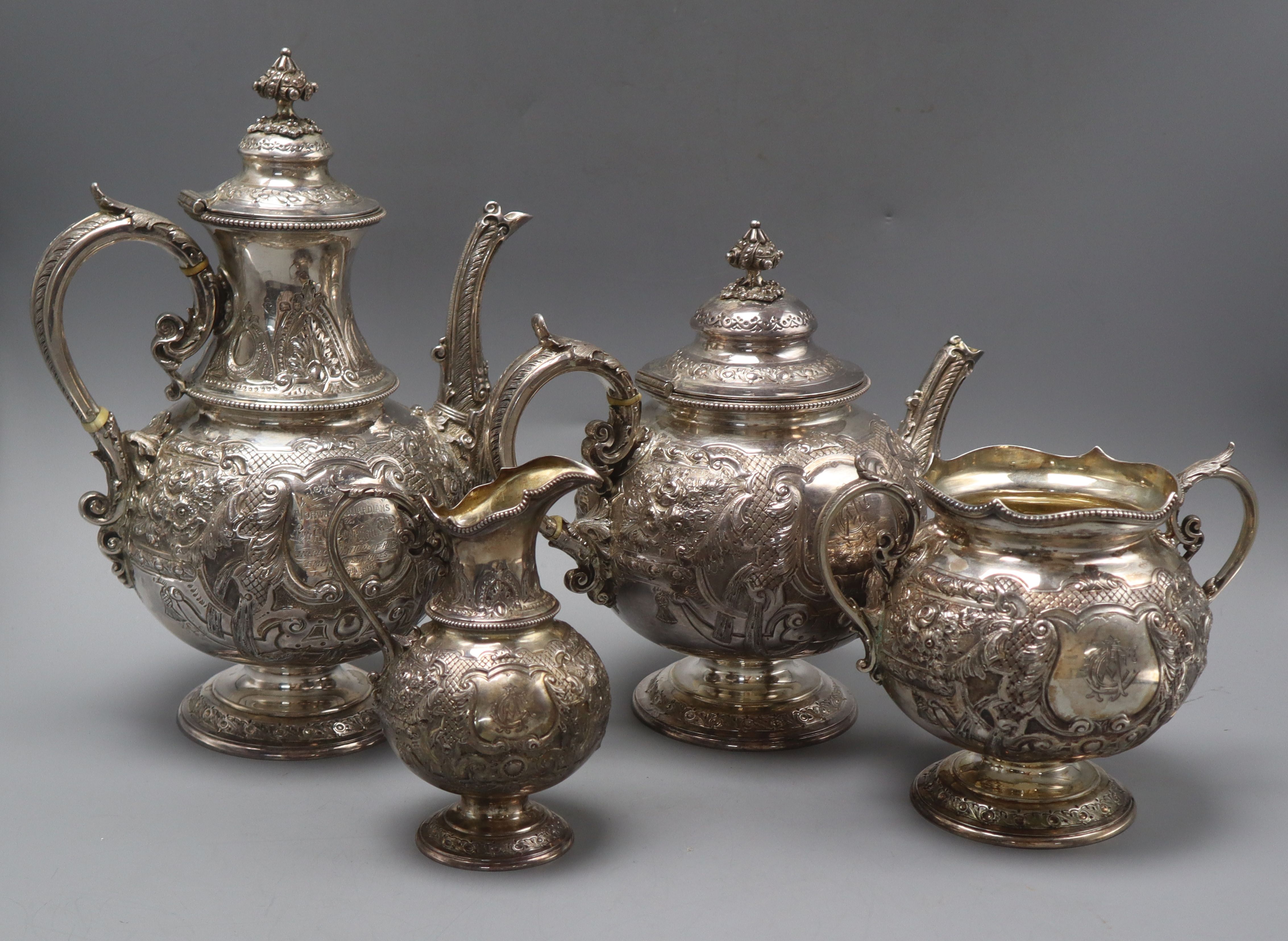 A late Victorian ornate embossed silver four piece tea & coffee set, comprising, two pots and