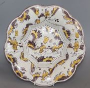 A Dutch Delft lobed flower shaped dish, late 17th century, painted in manganese and yellow (hairline