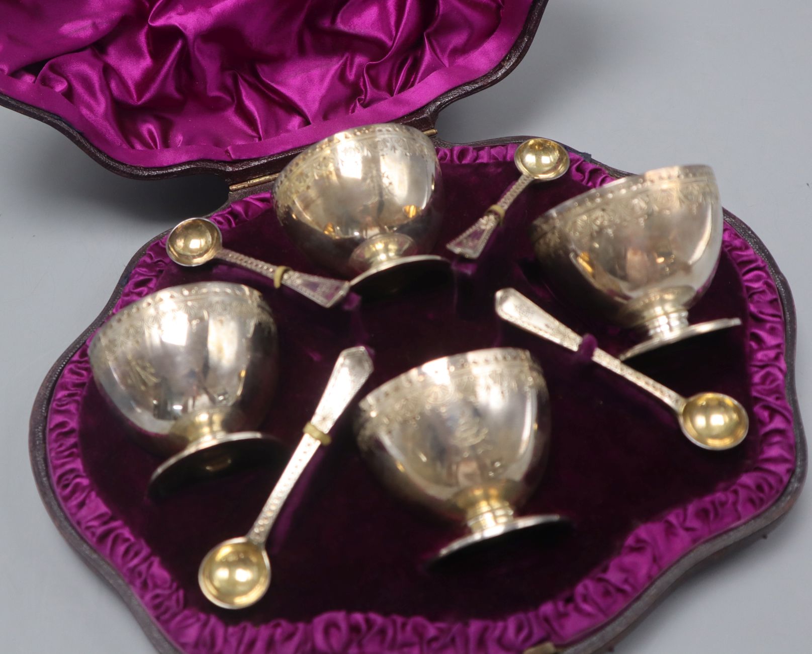A cased set of 4 Victorian engraved silver salts and four spoons, London, 1882. - Image 2 of 2
