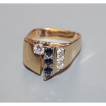 A modern 14k yellow metal, sapphire and diamond set dress ring, with square shaped shank, size P