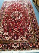 A Persian red ground carpet 260 x 150cm