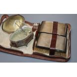 A gentlemen's silver-mounted grooming set in leather case and a silver engine-turned shaped oval