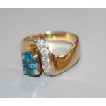 A modern 750 yellow metal, blue zircon and diamond set dress ring, size T.