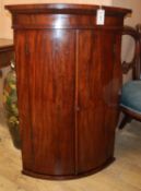 A George III mahogany bow front hanging corner cabinet H.100cm
