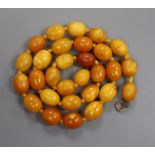 A single strand oval amber bead necklace, gross 35 grams, 50cm.