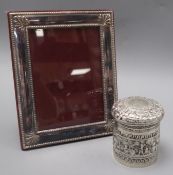 An Indian repousse white metal jar and cover and a silver plated photograph frame.