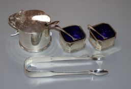 A silver drum mustard, a pair of Georgian silver fiddle pattern sugar tongs and a pair of silver