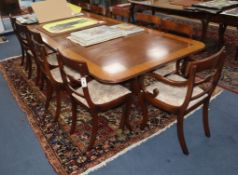 A Regency style satinwood banded mahogany twin pillar extending dining table together with a set