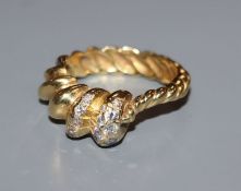 A modernist yellow metal and diamond set spiral form dress ring, size P.