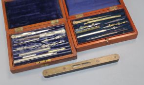 Two cased drawing sets and a level