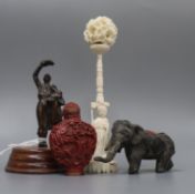 A carved ivory concentric ball on stand, a snuff bottle, an elephant pin cushion and a miniature