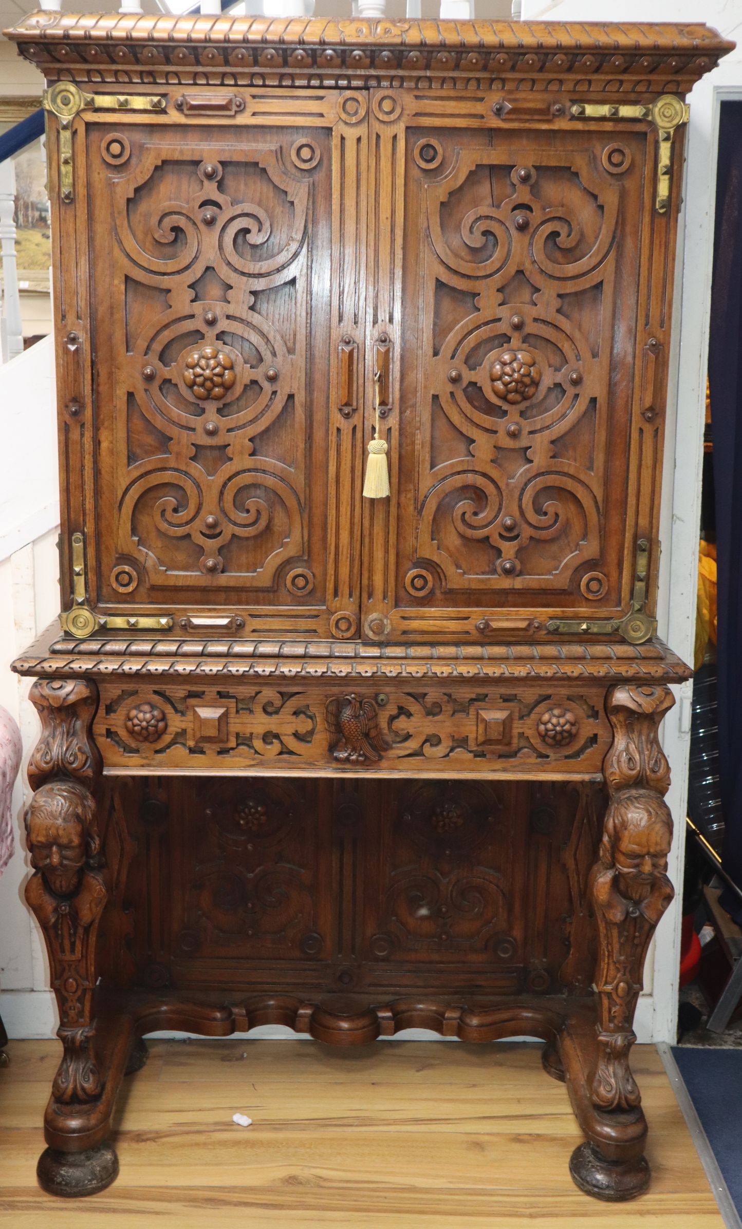 A mid 19th century carved oak cabinet on stand, in the manner of Richard Bridgens, enclosed by