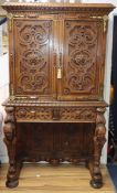 A mid 19th century carved oak cabinet on stand, in the manner of Richard Bridgens, enclosed by