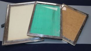 Two silver mounted rectangular photograph frames and a white metal and niello photograph frame.